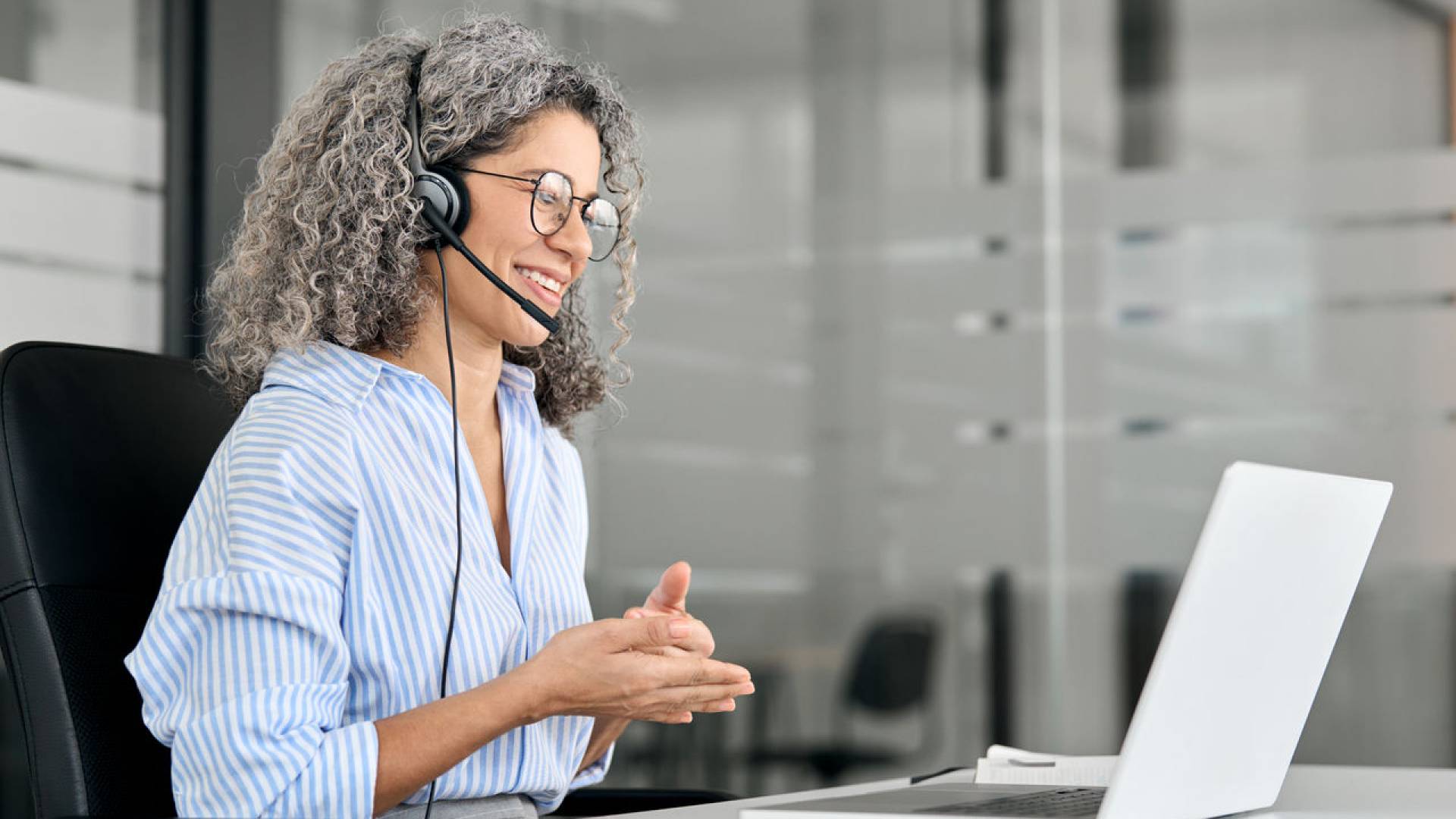 Happy middle aged woman call center customer support agent working in office.