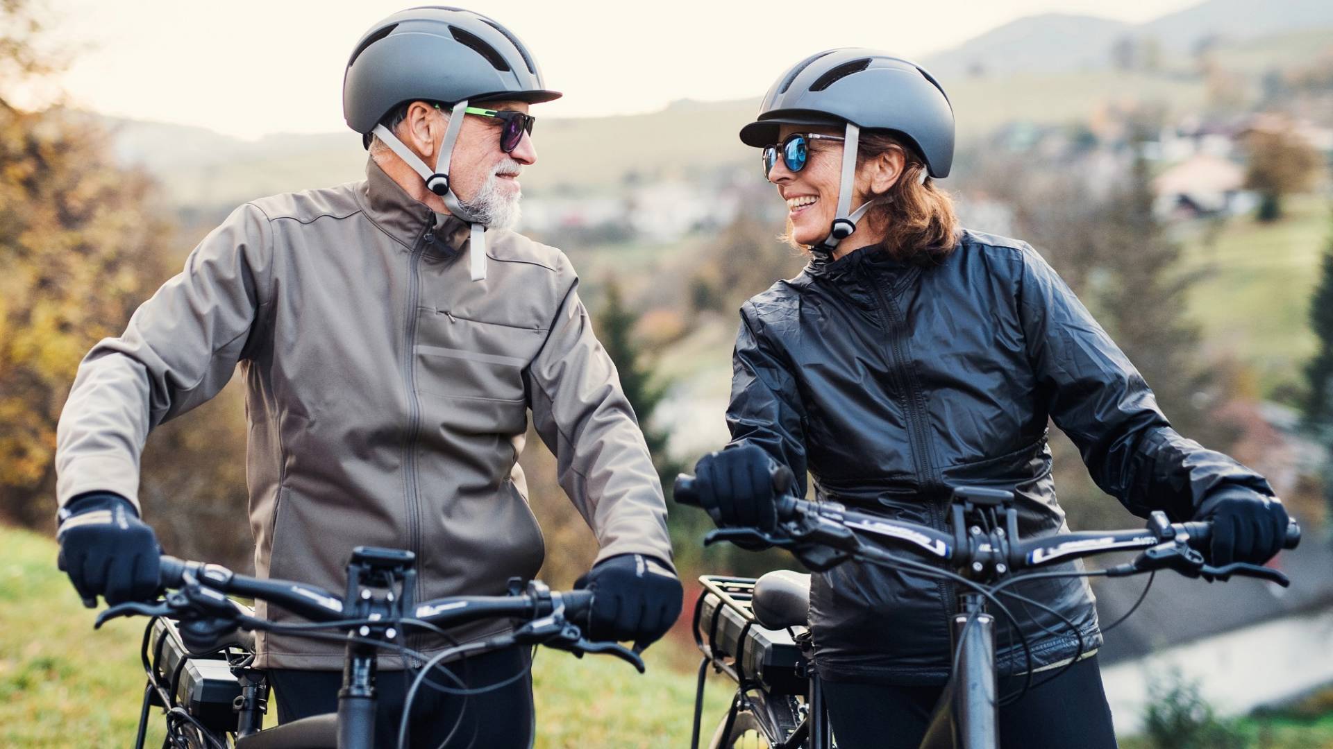 Ein aktives Seniorenpaar mit Helmen und E-Bikes