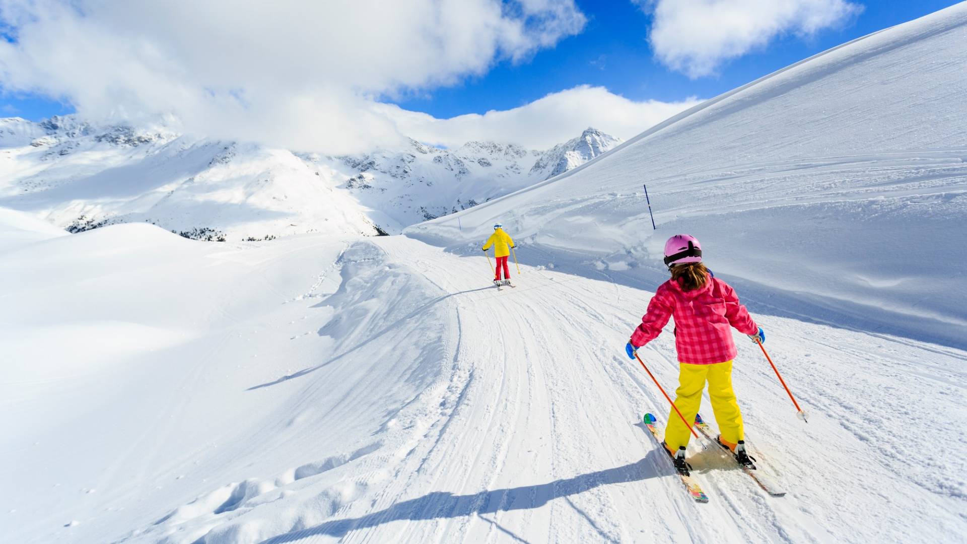 Zwei Kinder beim Skifahren auf der Piste.