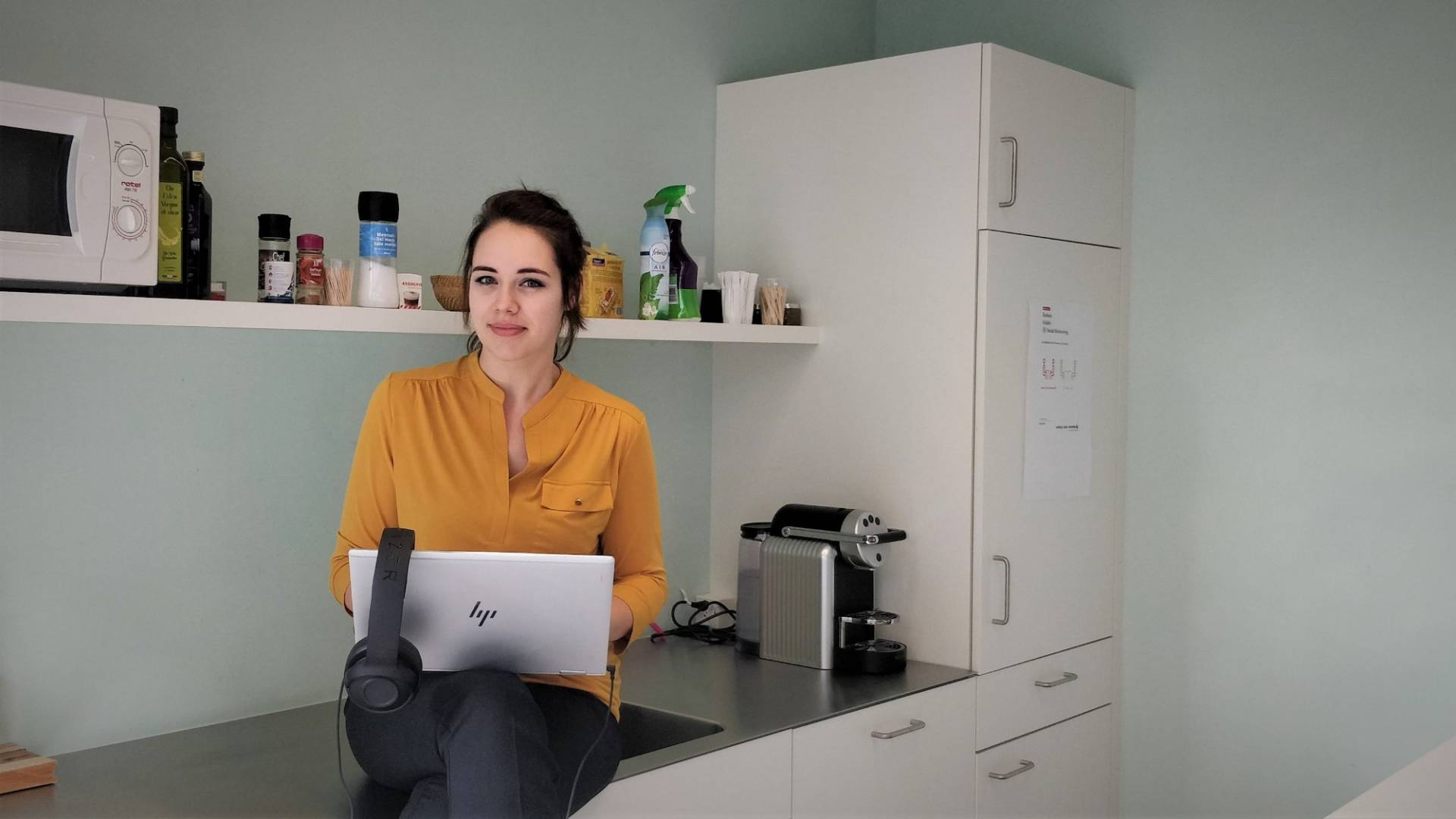 Caroline Stalder is sitting in the kitchen at her laptop.