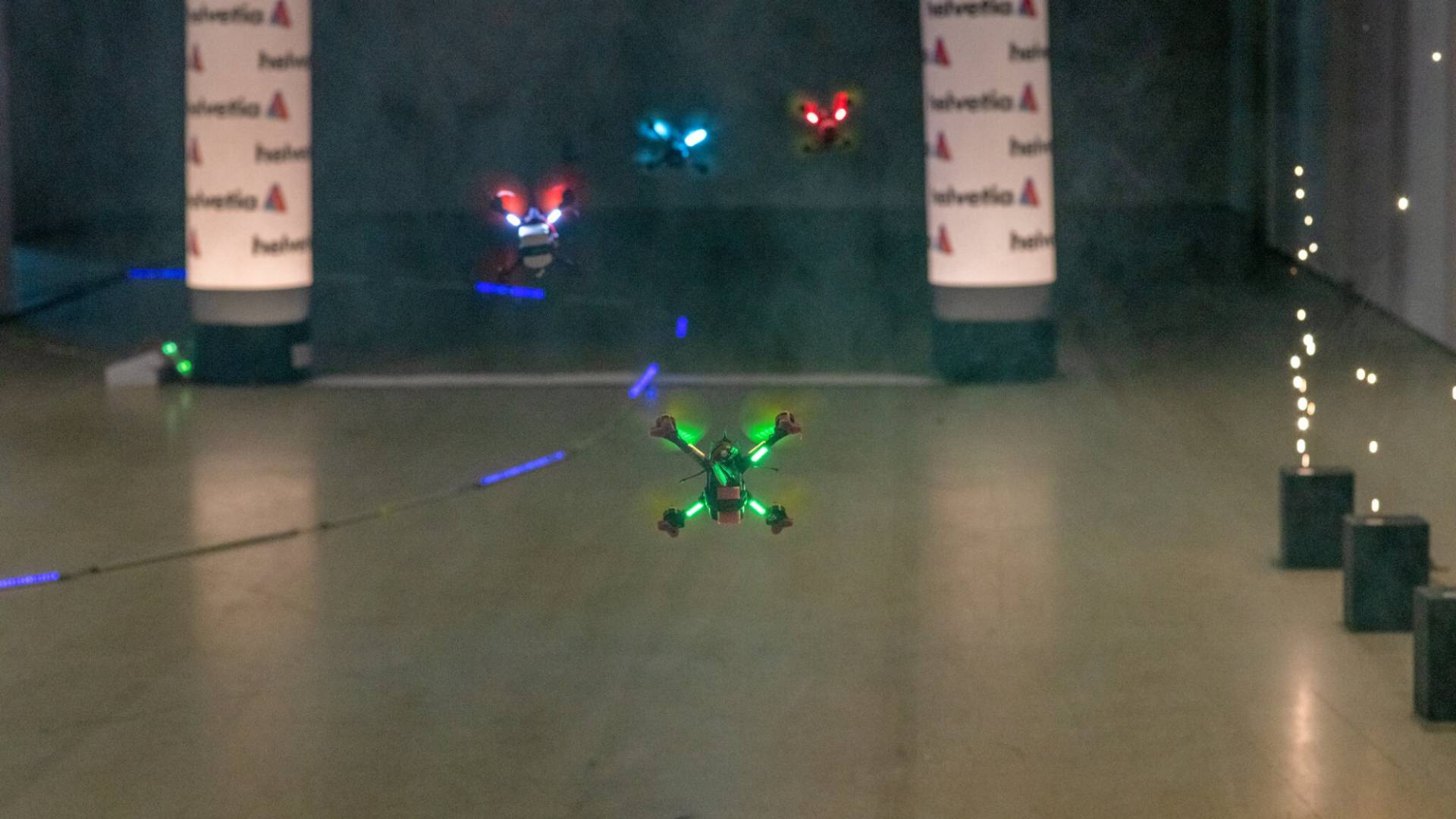 Drones fly around obstacles along the race course.