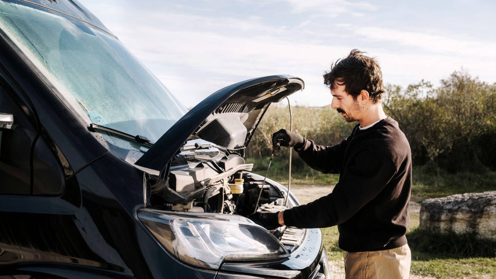 A man whose car has broken down in the countryside.