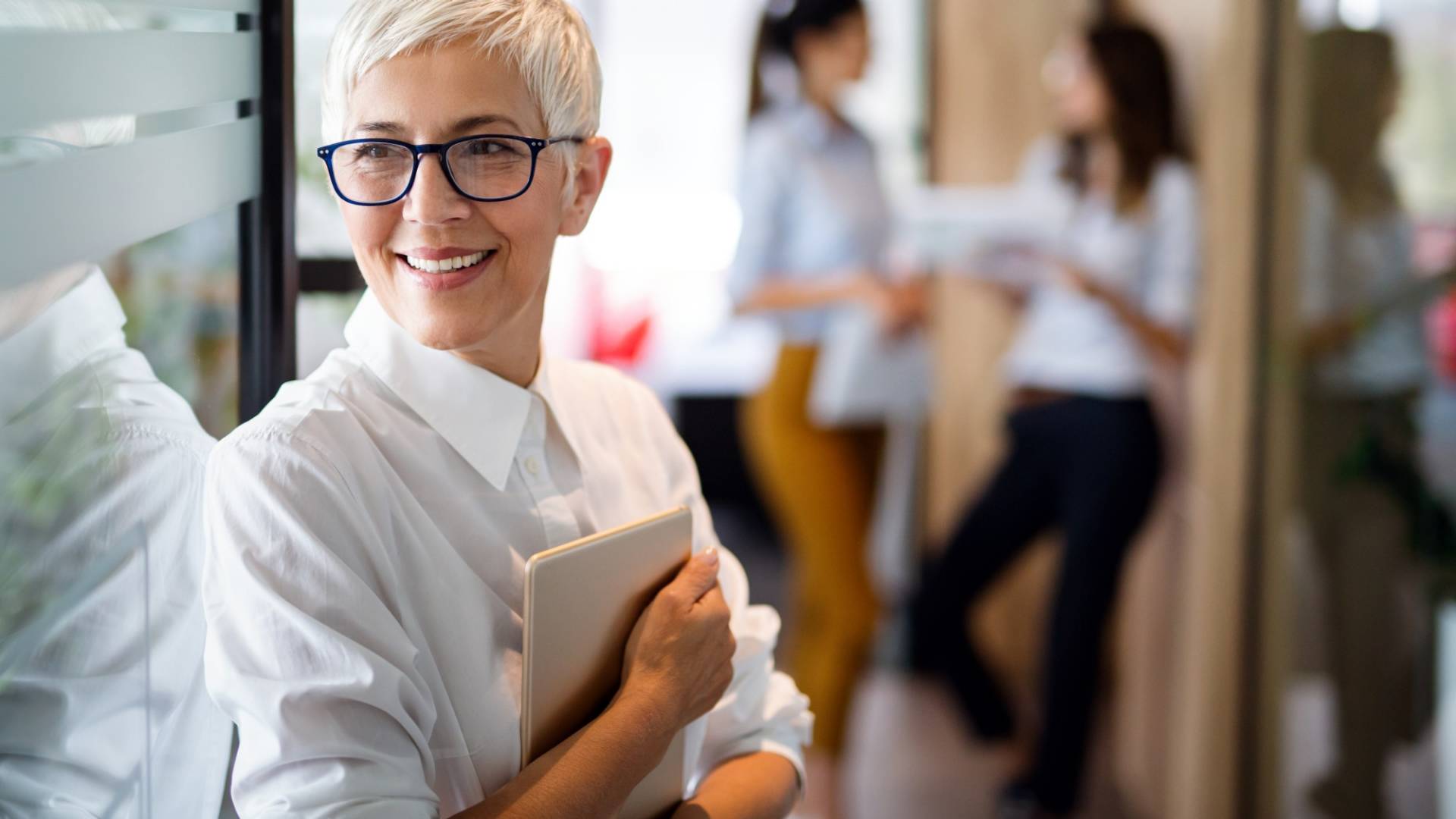 Confident stylish european mature business woman standing at wor