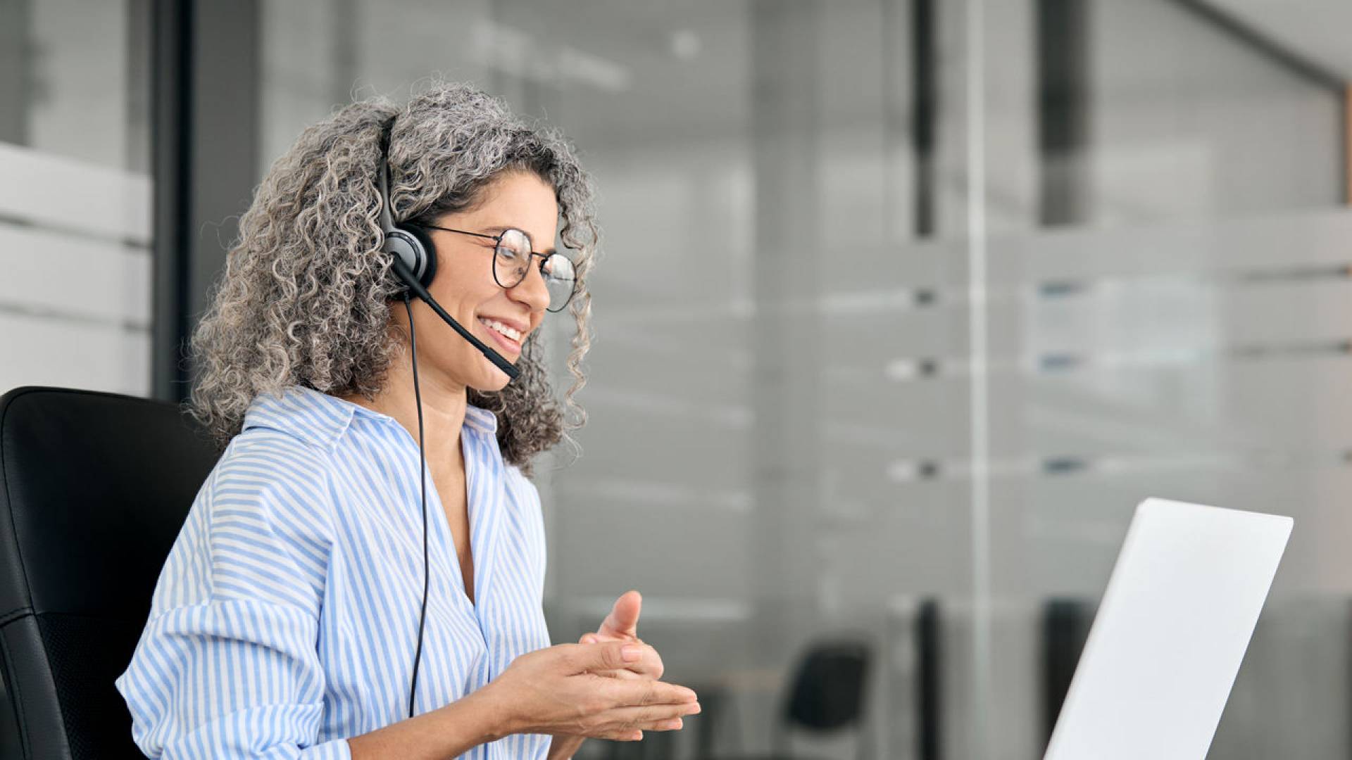 Happy middle aged woman call center customer support agent working in office.