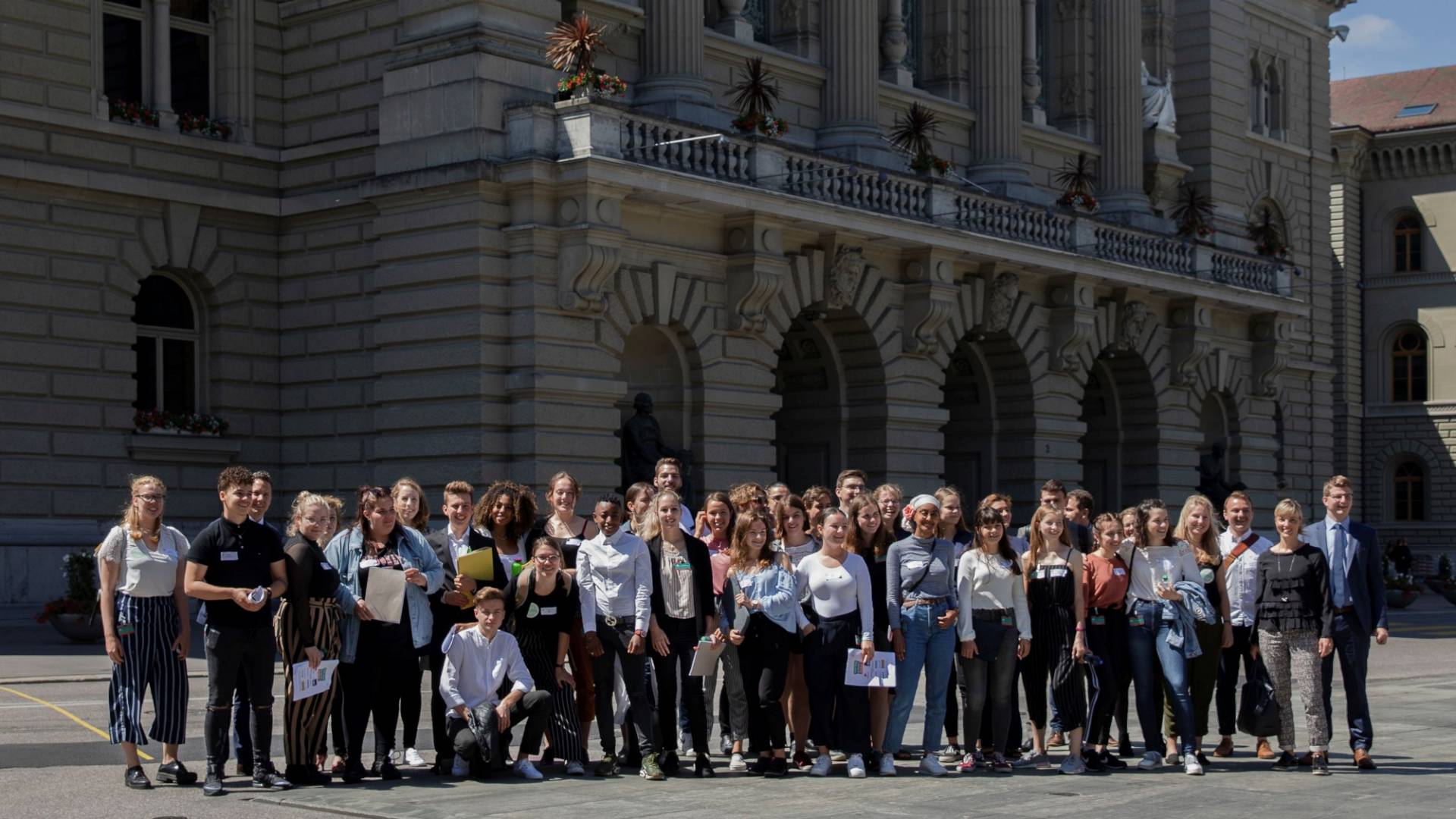 Un groupe de jeunes devant le Palais fédéral à Berne.