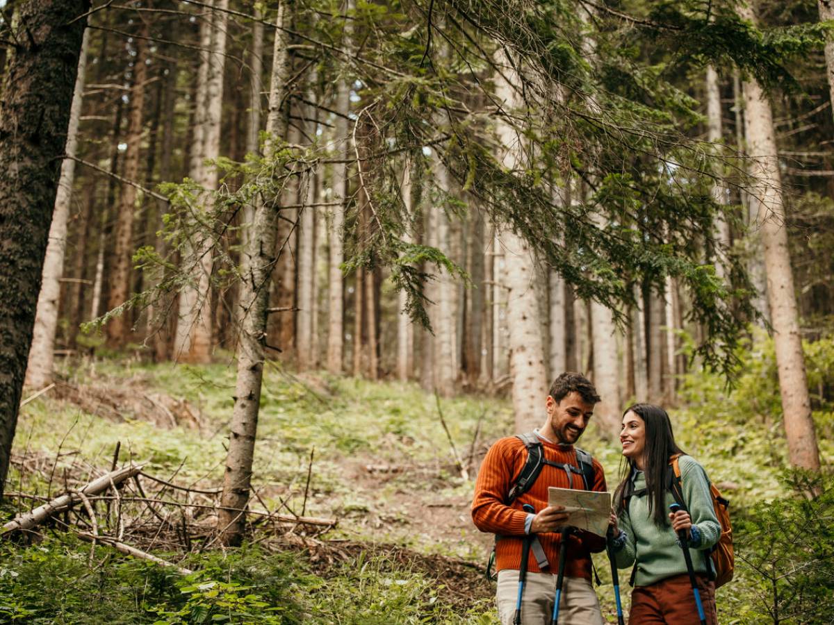 Une femme et un homme dans la forêt, munis d'une carte de randonnée.