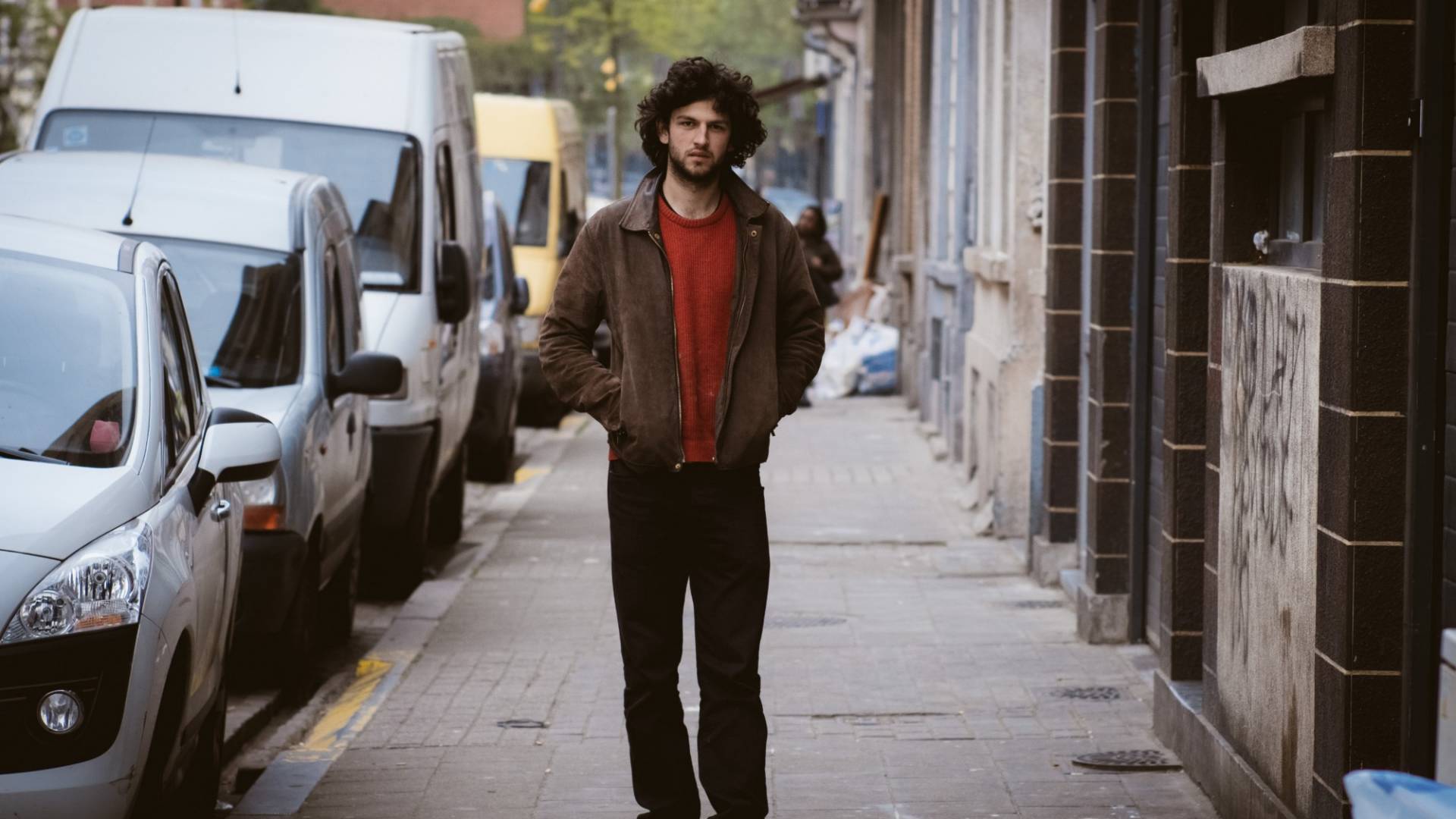 Andriu Deplazes flâne dans les rues de Bruxelles, les mains dans les poches de sa veste.