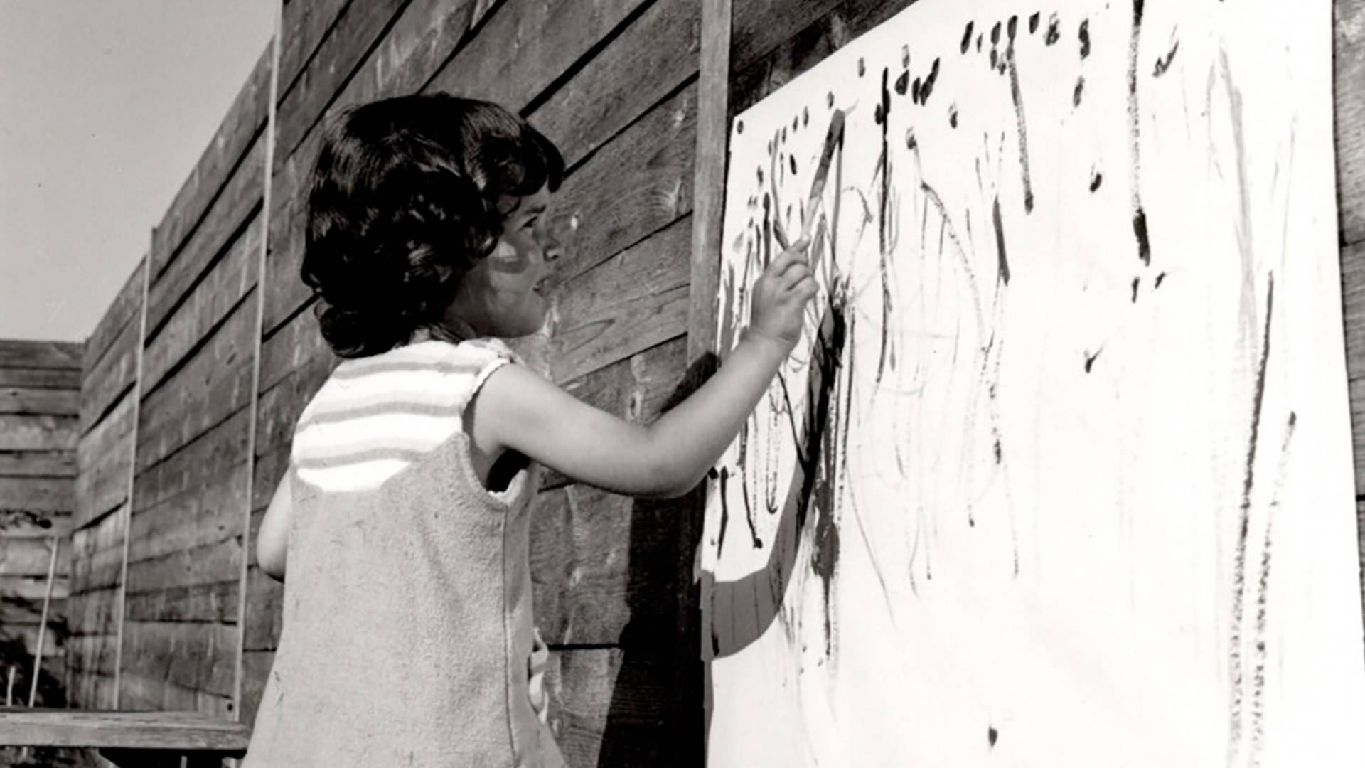 L'artiste Tüpf Li/Sabina Speich en tant qu'enfant peignant dans le jardin.