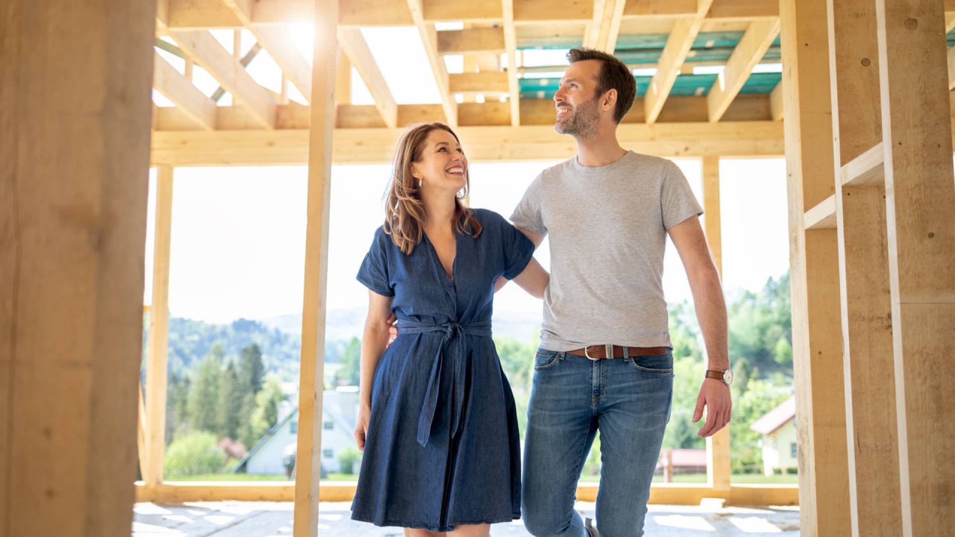 Wife and husband visiting building site of their new house with construction in background