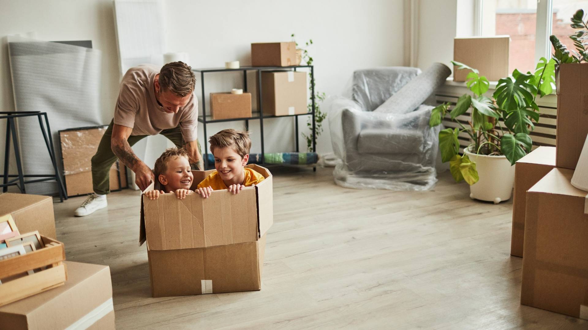Father Playing with Sons in New Home