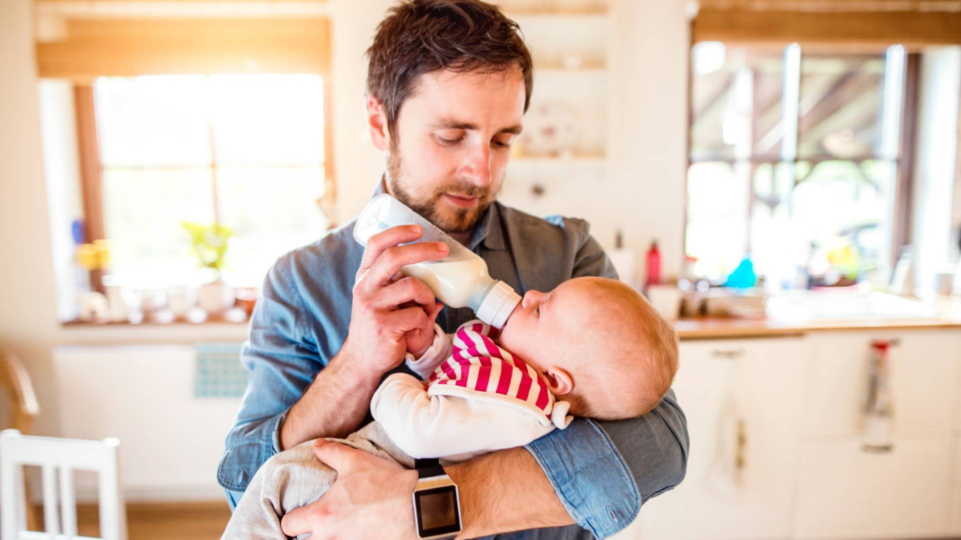 Un père avec un nouveau-né dans les bras.