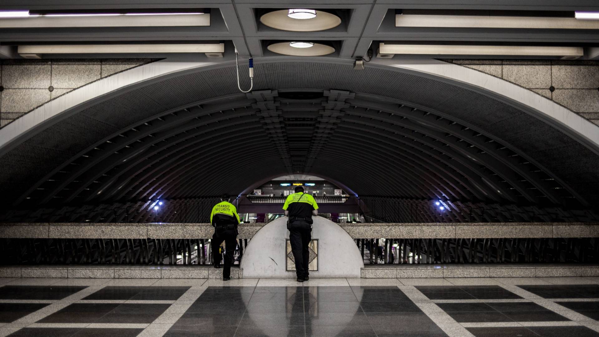 Tunnel ferroviario con due uomini della sicurezza che dall'alto guardano il tunnel.