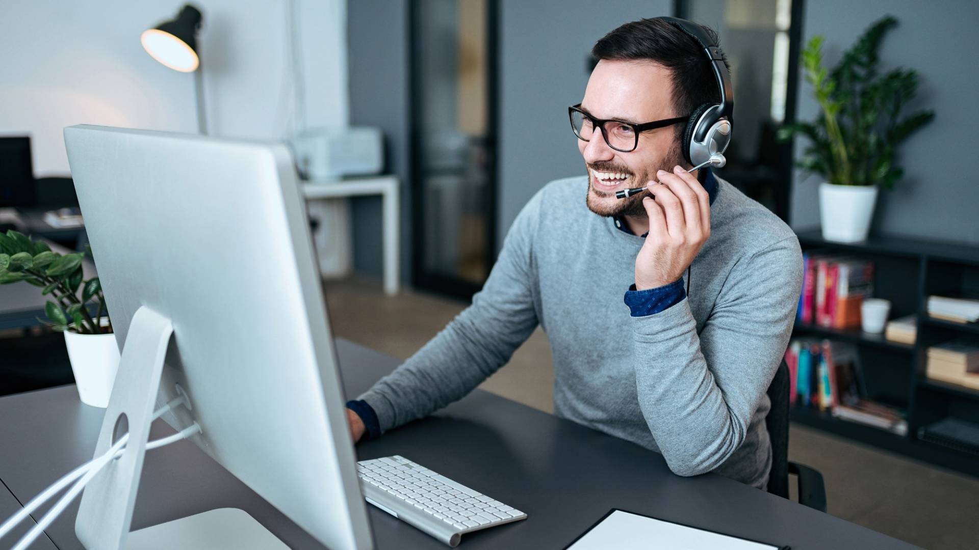 Fröhlicher Mitarbeiter telefoniert mit Kunde