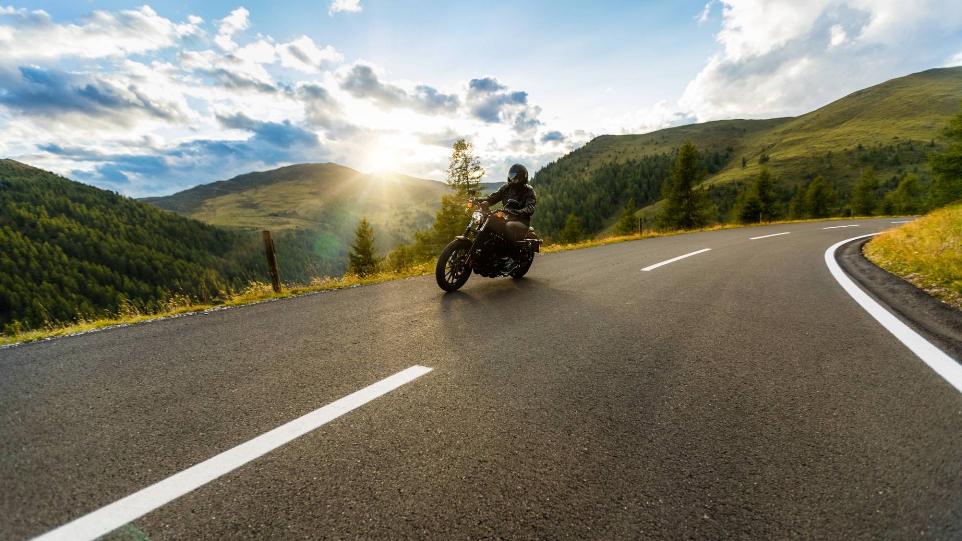 Motorcycle driver riding in Alpine highway, Nockalmstrasse, Austria, Europe.