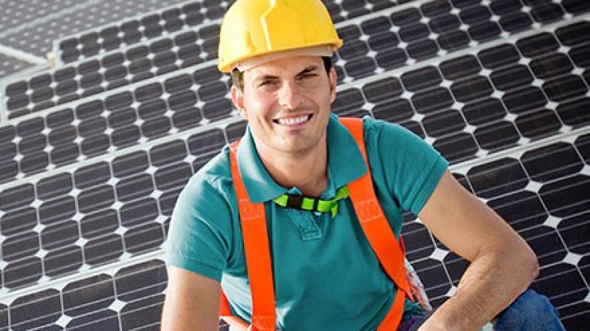 EIn Handwerker vor einer Photovoltaikanlage