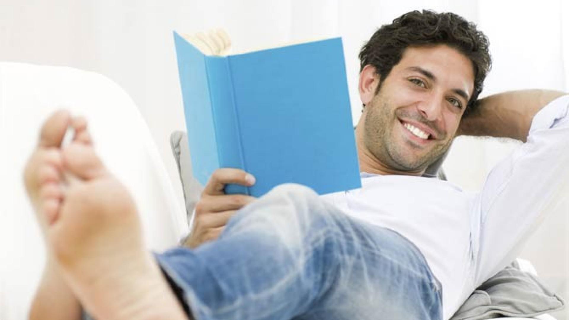 Mann liegt im Krankenhaus und liest ein Buch