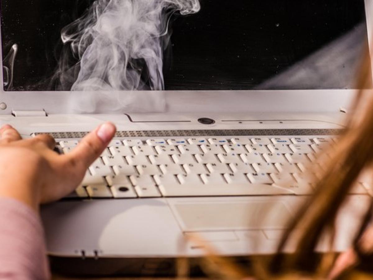 Aus einem Laptop steigt Rauch auf.