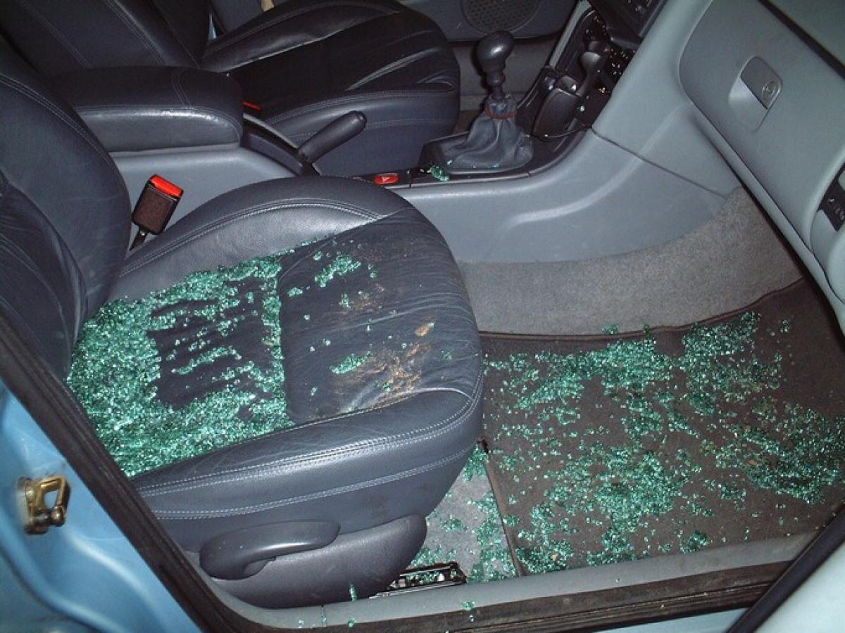 Auf einem Autositz sind Glasscherben von einer eingeschlagenen Fensterscheibe zu sehen.