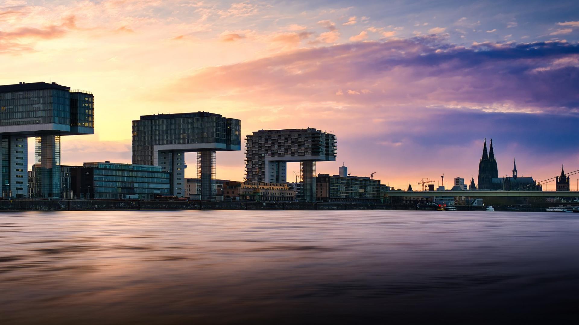 Lächelnde Frau mit Afrofrisur hält ein Tablet in der Hand. 