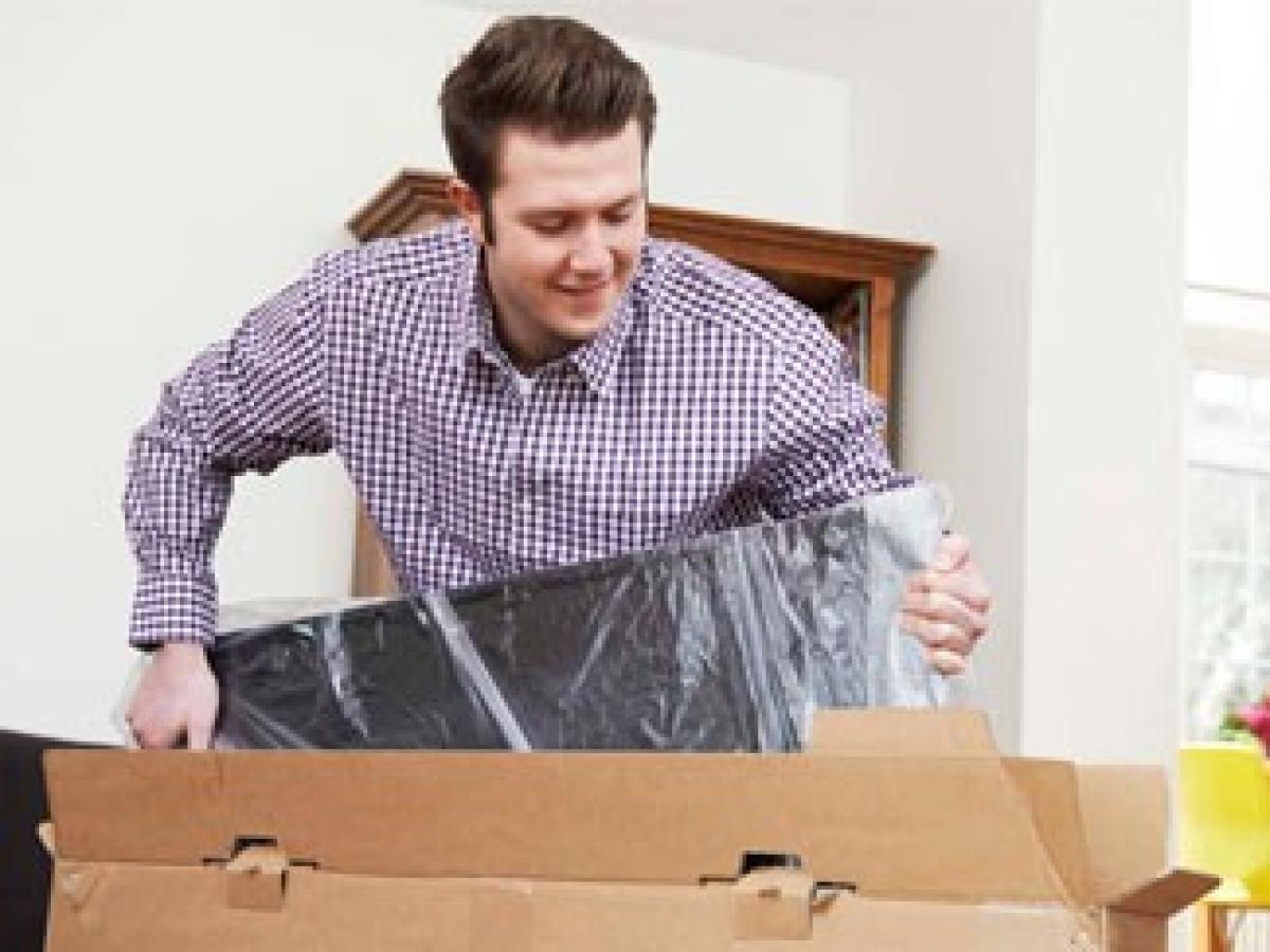 Ein Mann packt Sachen in eine Box für seinen Umzug