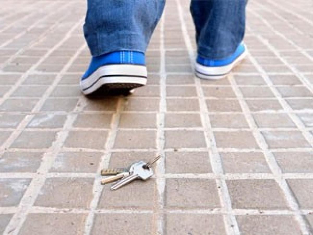 Eine Person verliert seinen Schlüssel auf dem Boden
