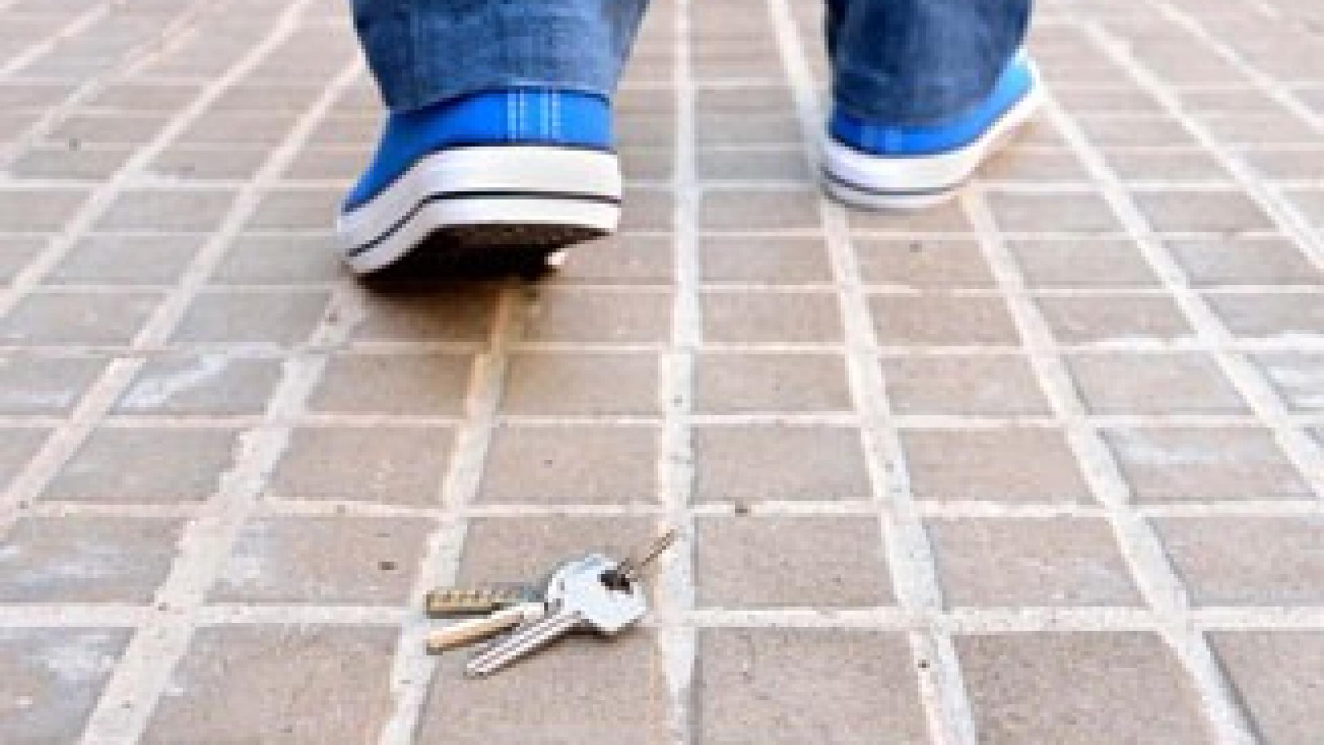 Eine Person verliert seinen Schlüssel auf dem Boden