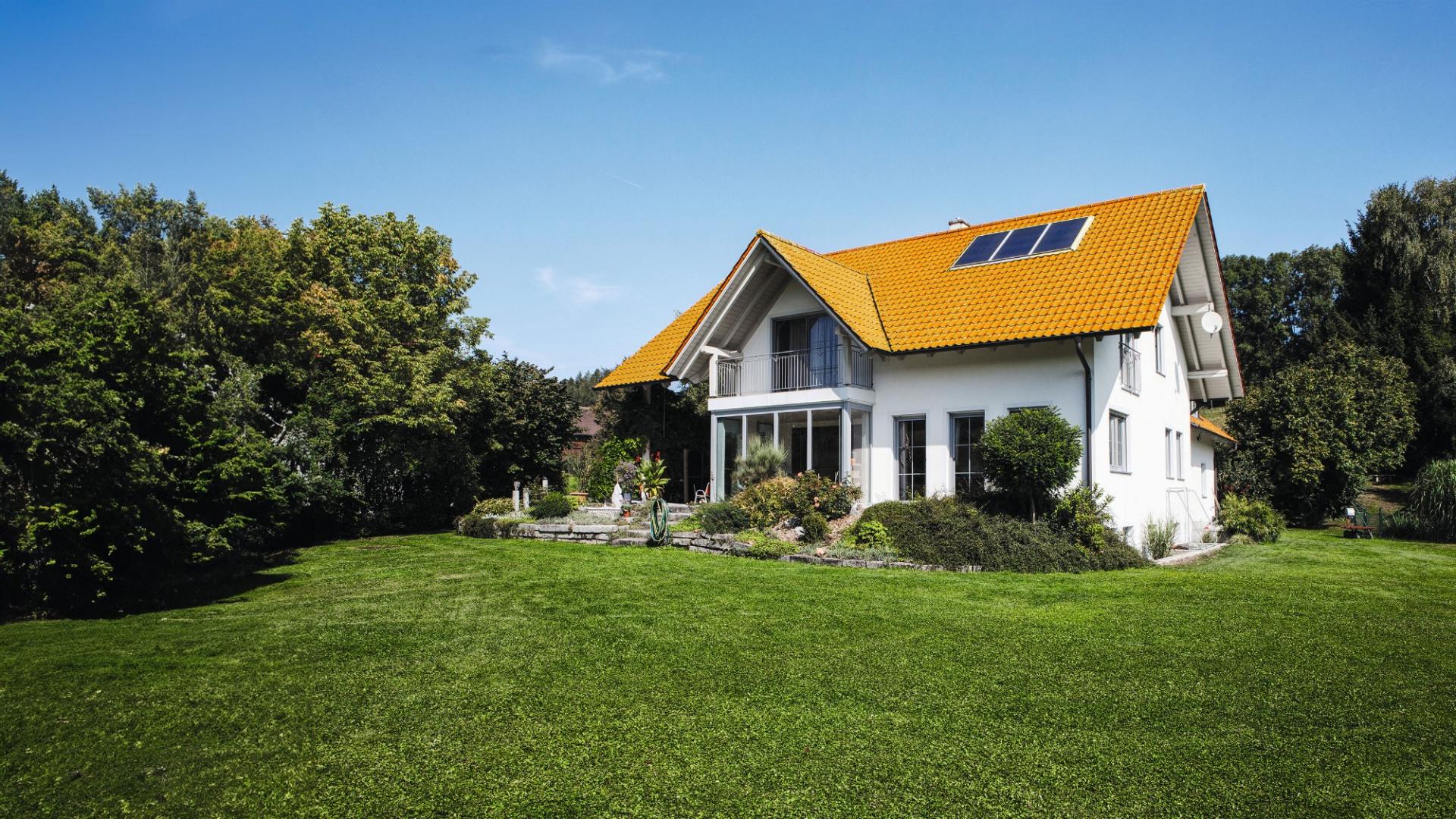 Ein weißes Haus mit einer grünen Wiese