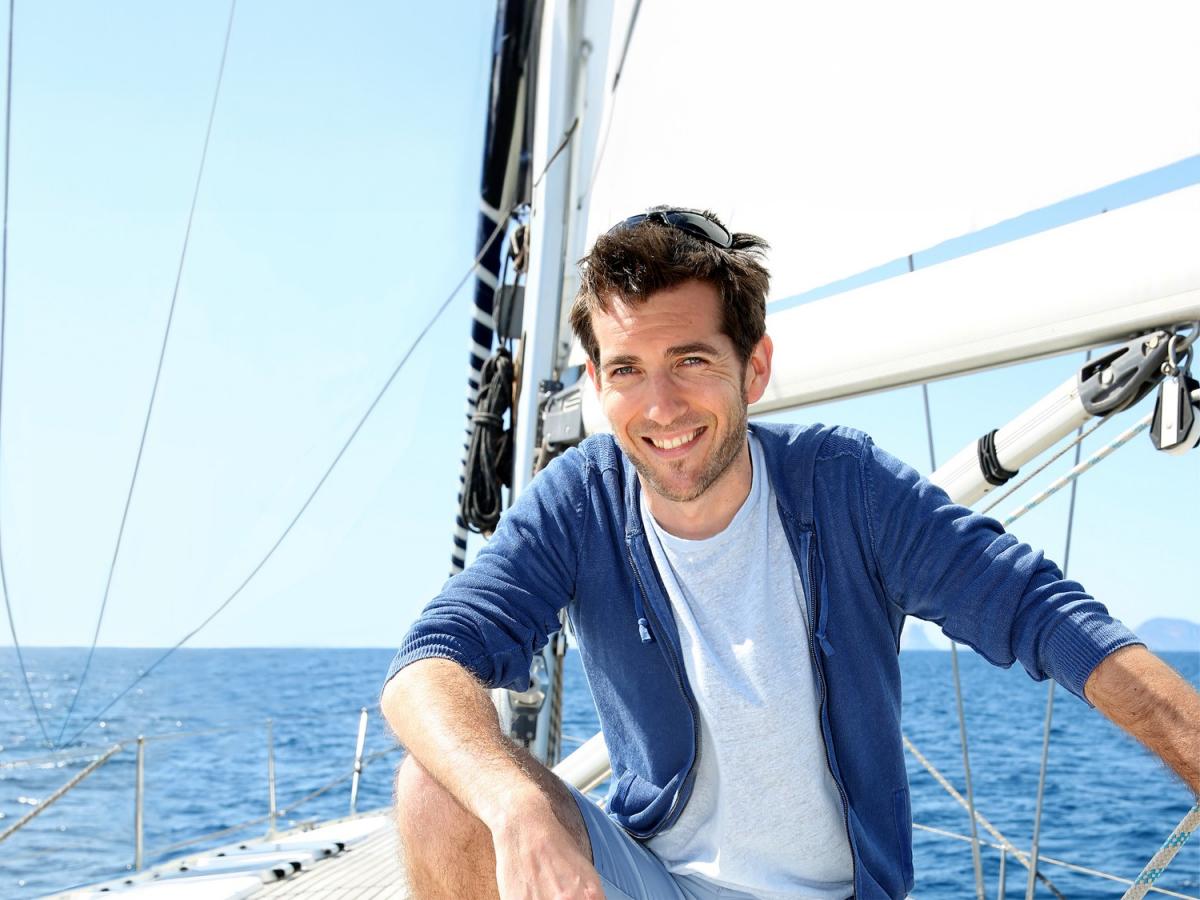 Ein Mann auf einem Boot der lächelt