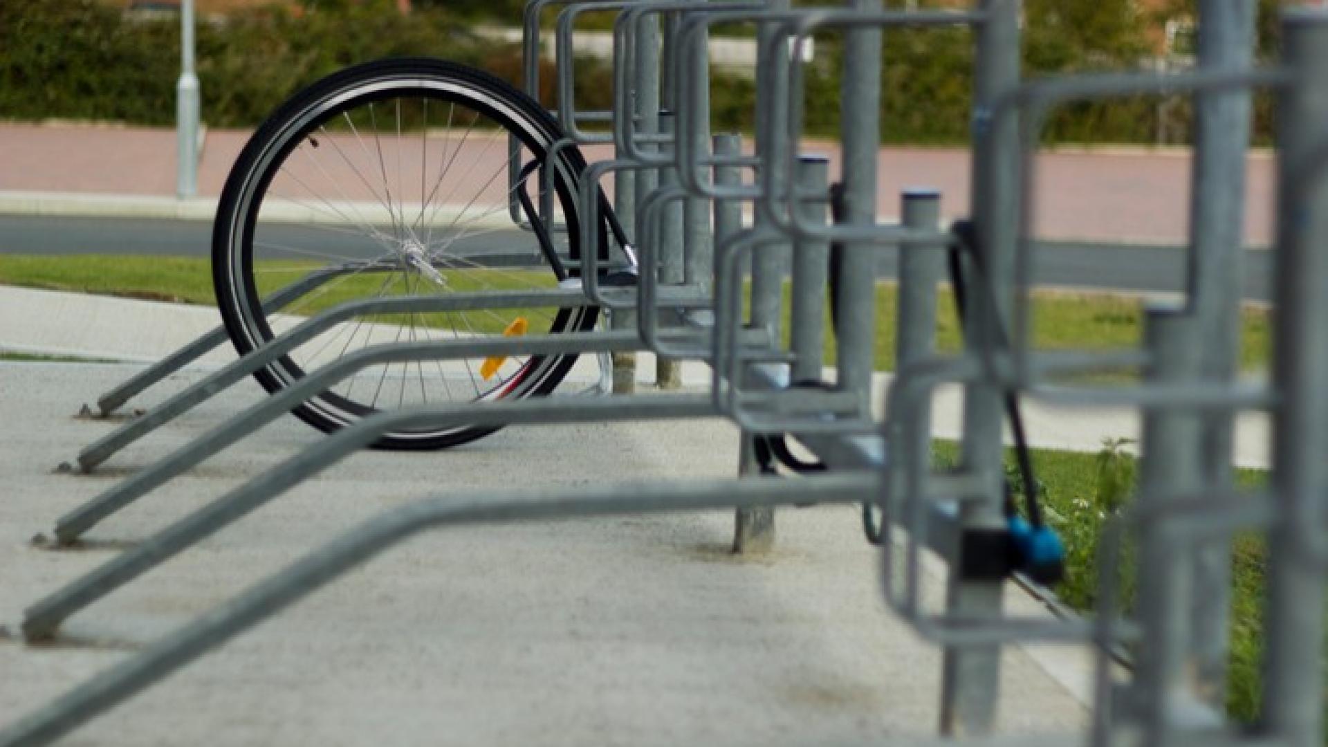 An einem Fahrradständer ist ein einzelner Reifen angekettet da scheinbar das restliche Fahrrad gestohlen wurde.