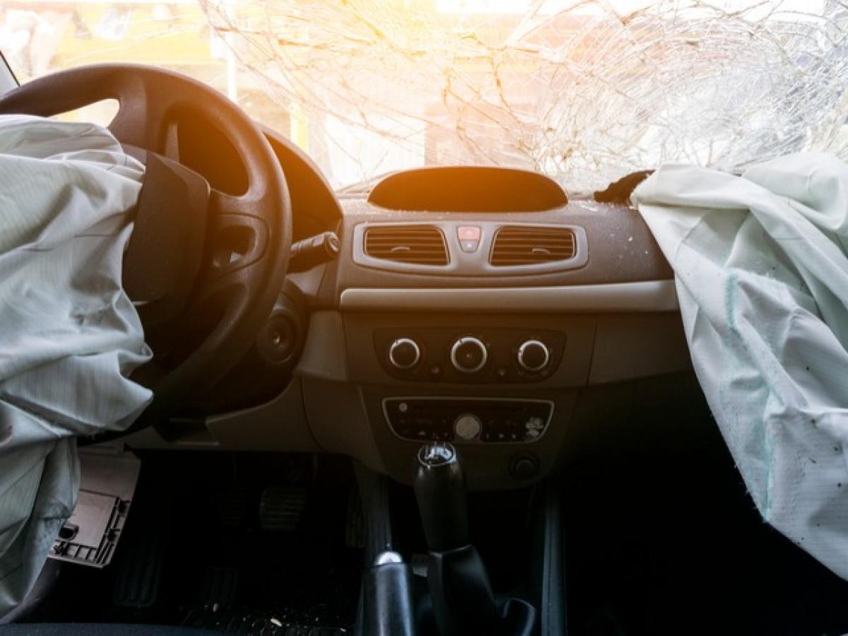 Bild mit geöffneten Airbags und kaputter Frontscheibe vom Inneren eines Autos nach einem Unfall.