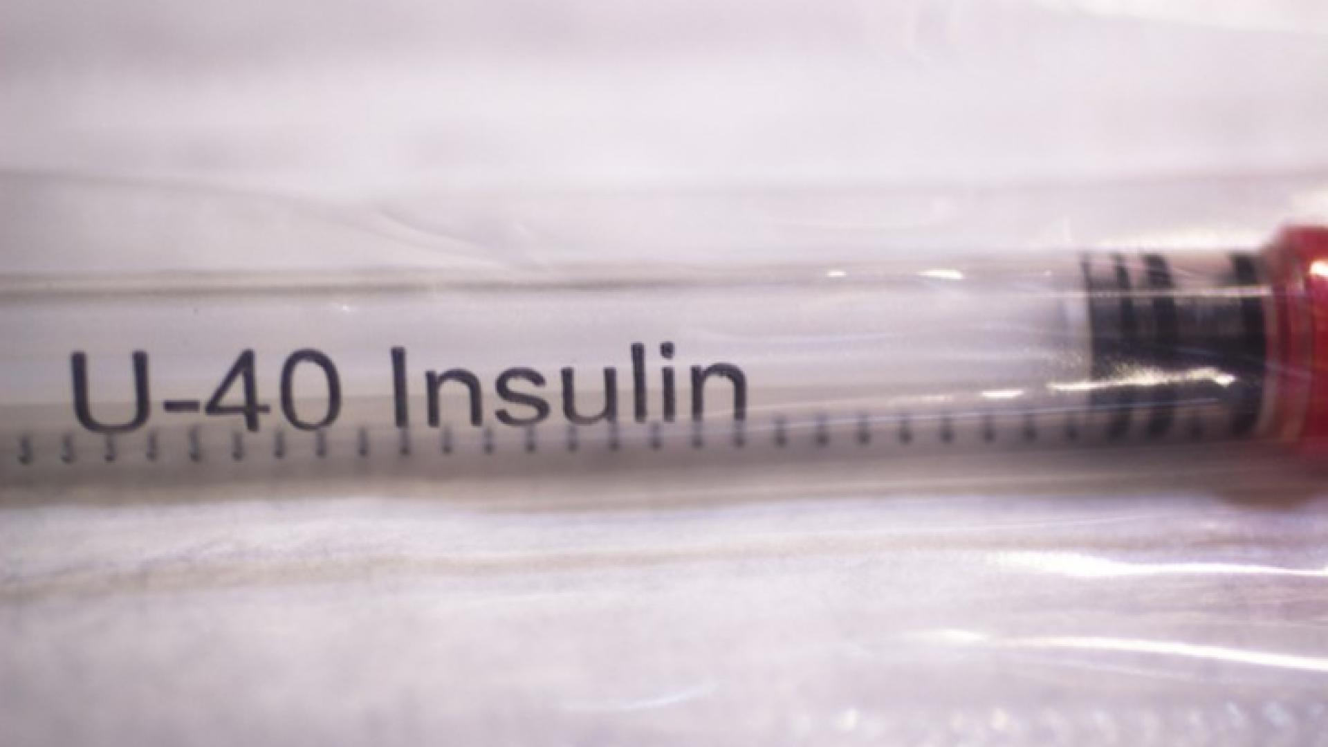Eine Spritze mit Insulin liegt auf einer Unterlage.