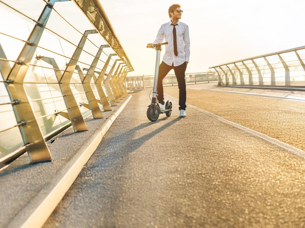 Frau mit E-Scooter im Straßenverkehr