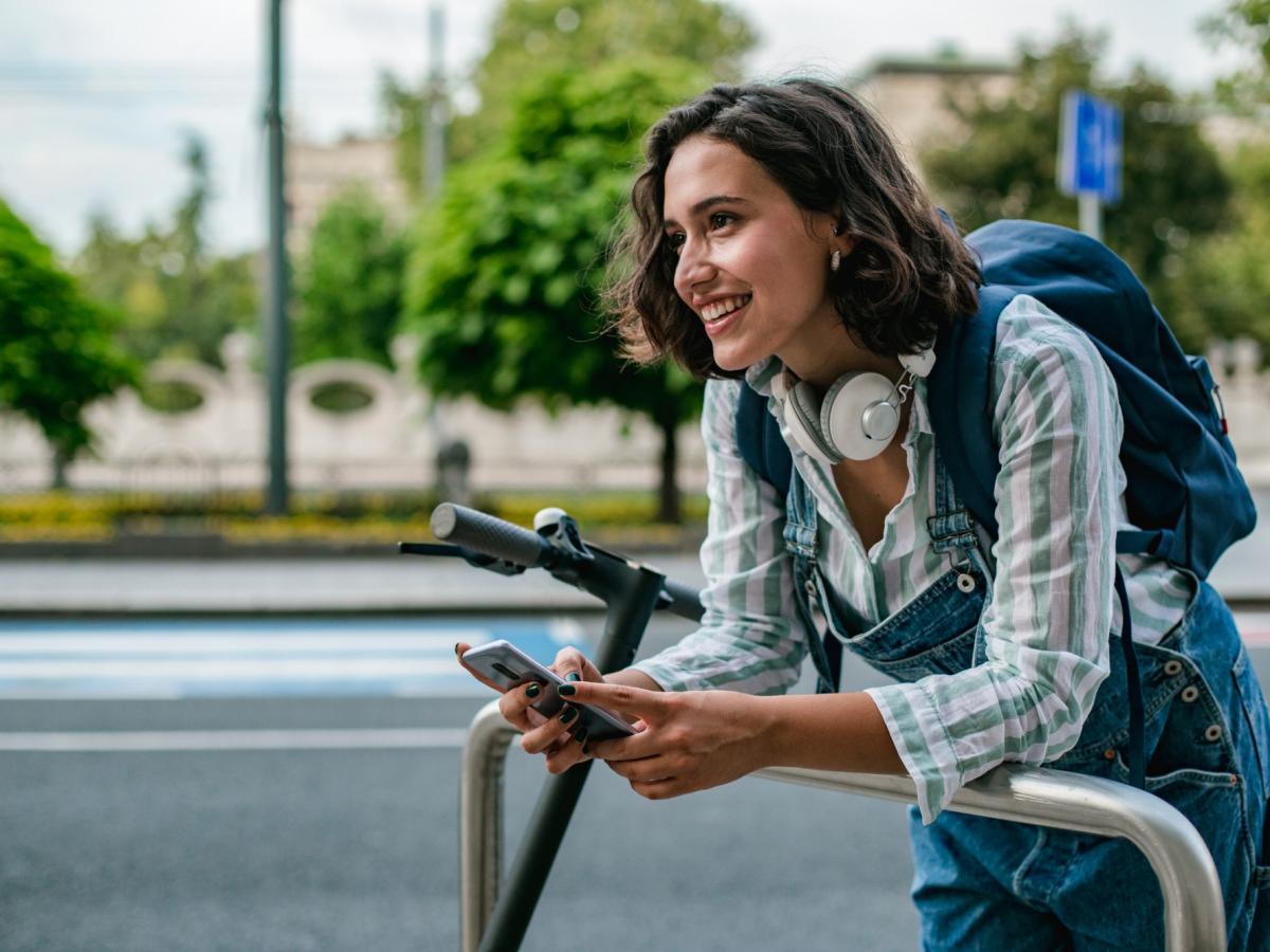 Frau auf E-Scooter im Straßenverkehr