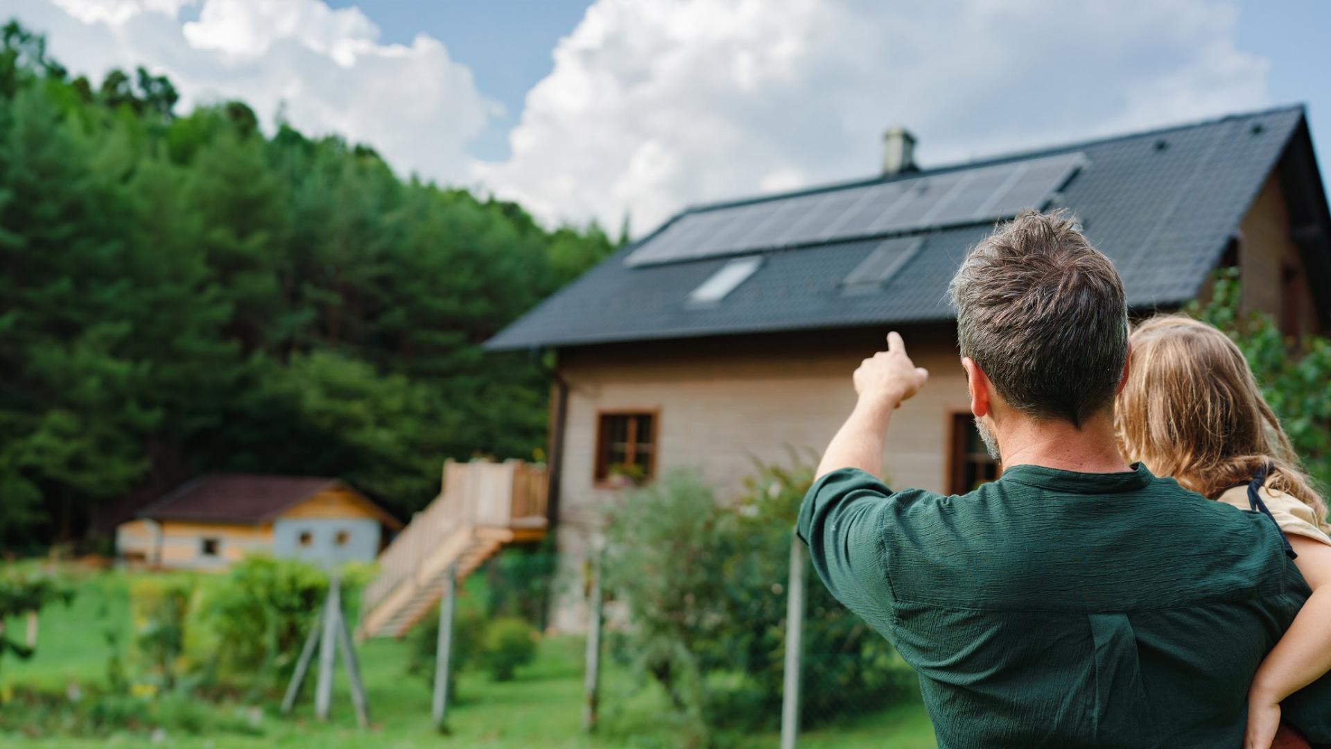 Auf dem Bild ist ein Mann auf einem Dach abgebildet, der eine Photovoltaikanlage installiert.