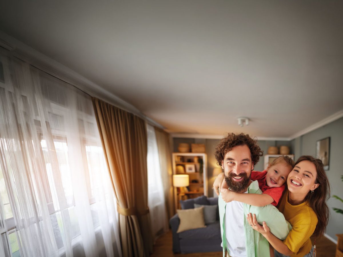madre, padre e figlia che sorridono in una casa