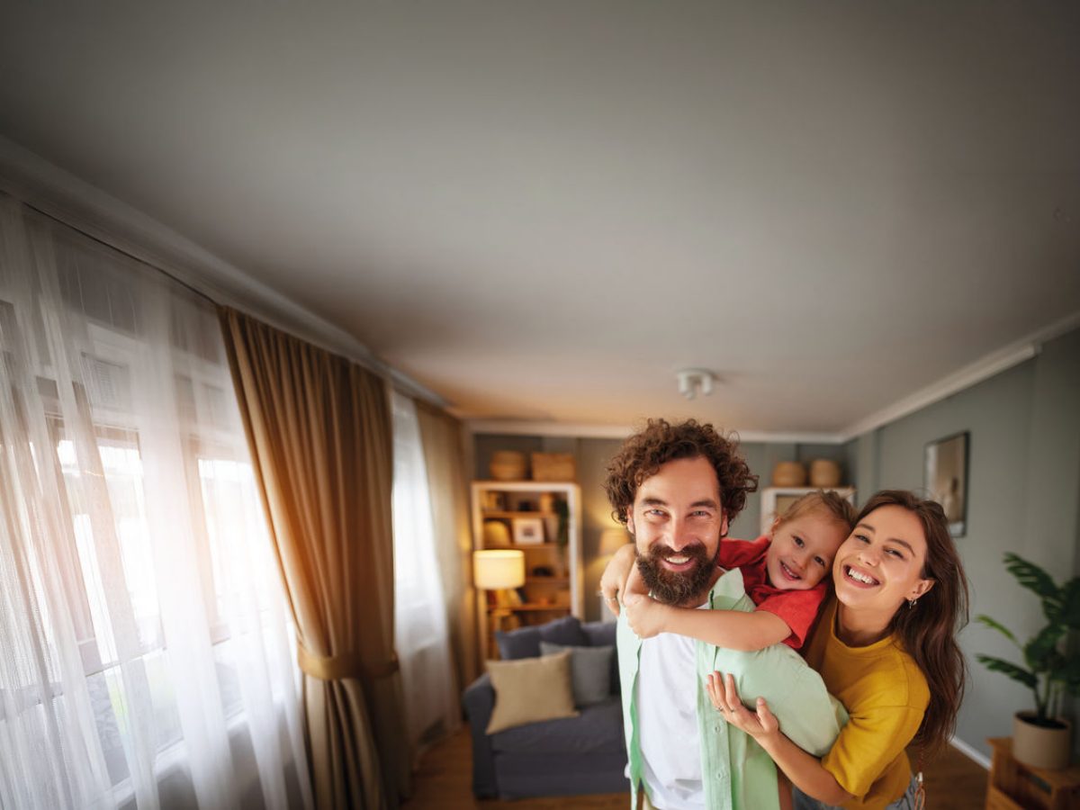 madre, padre e figlia che sorridono in una casa