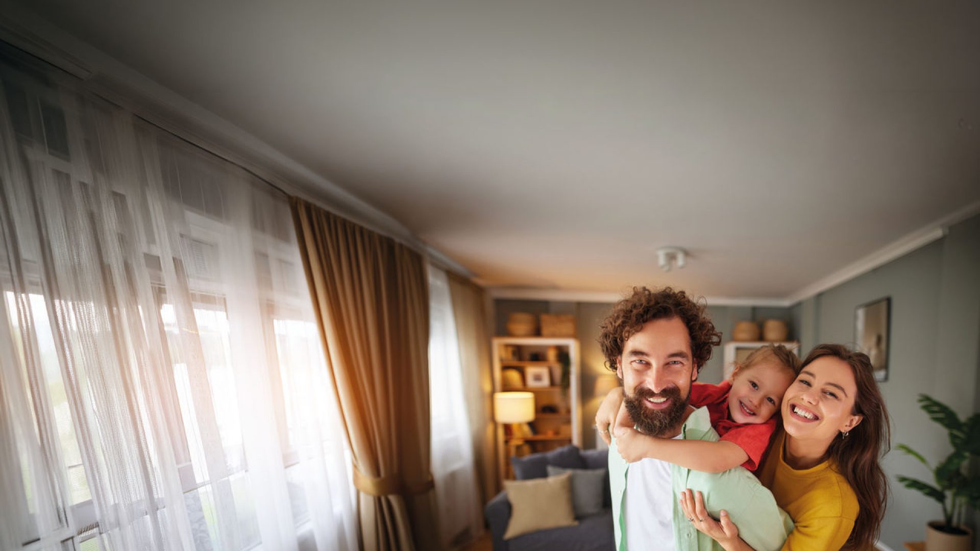 madre, padre e figlia che sorridono in una casa