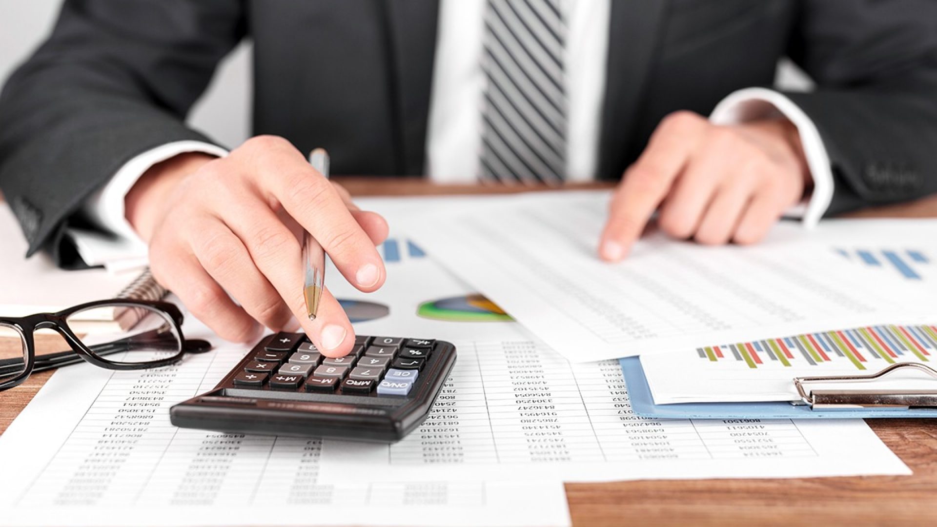Businessman working with using a calculator to calculate the numbers. Finance accounting concept