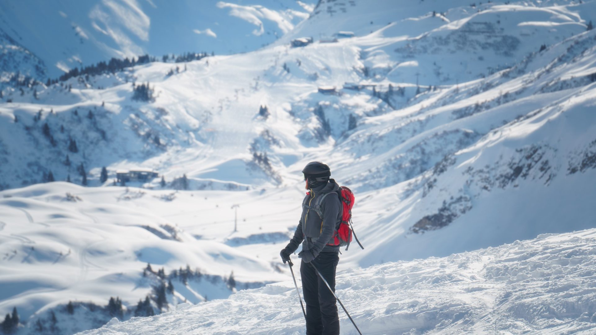 uomo che scia su piste innevate e soleggiate