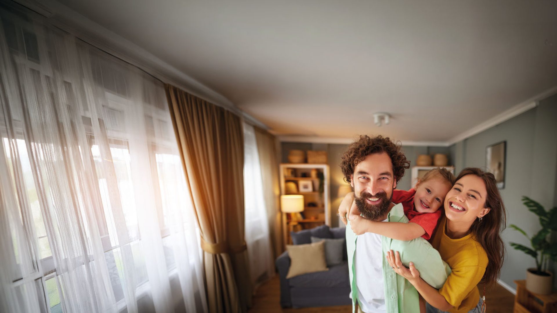 madre, padre e figlia che sorridono in una casa